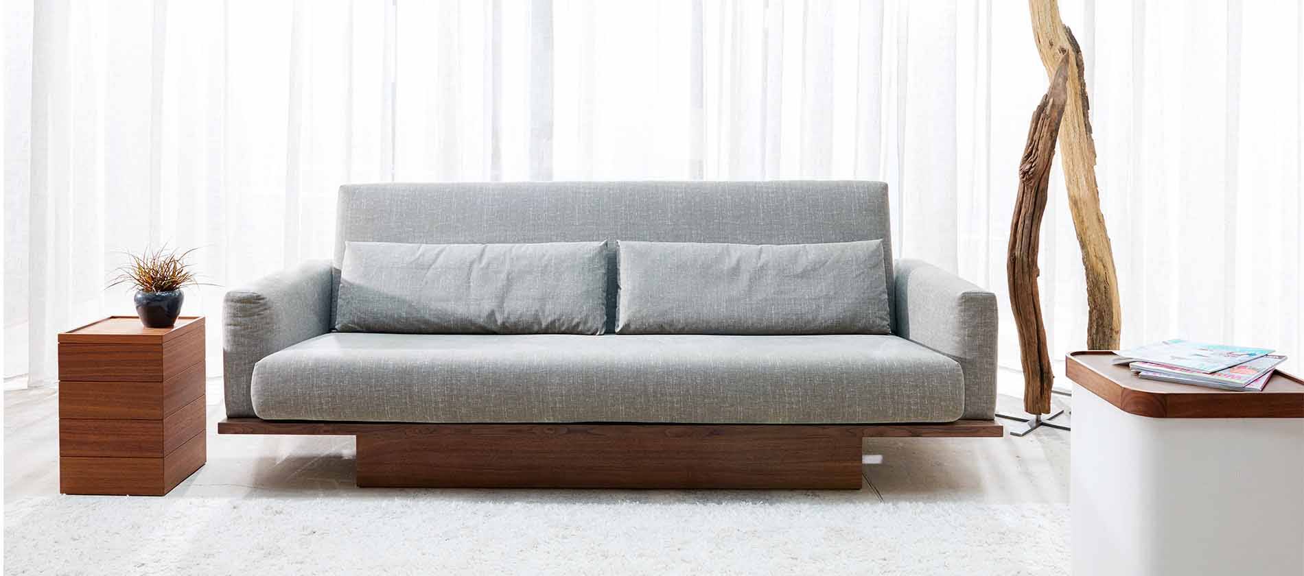 Das Schlafsofa Pio von Signet mit zwei Holzarmlehnen. Pio Schlafsofa Signet Querschläfer